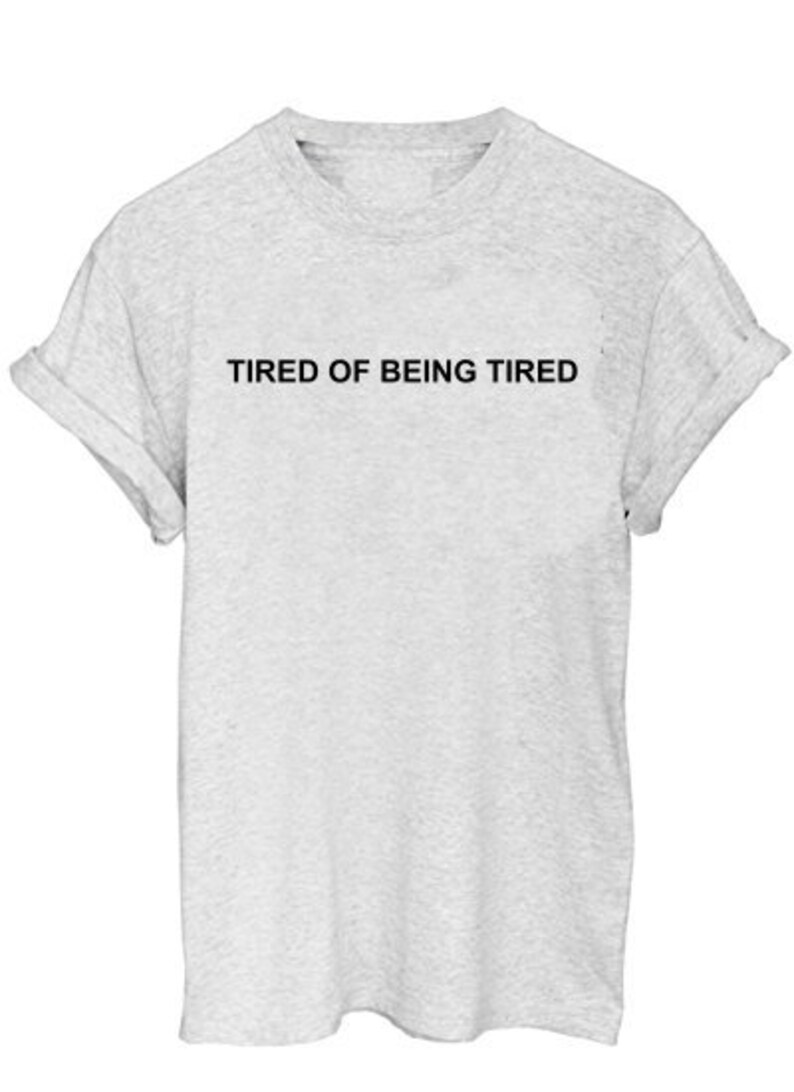 May include: A gray t-shirt with the text "TIRED OF BEING TIRED" printed in black.