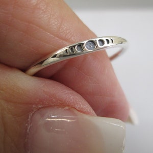 May include: A silver ring with a delicate design of crescent moons. The ring is simple and elegant, perfect for everyday wear.