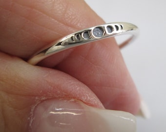 May include: A silver ring with a delicate design of crescent moons. The ring is simple and elegant, perfect for everyday wear.
