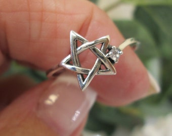 May include: A silver ring with a star of David design and a small clear stone accent.
