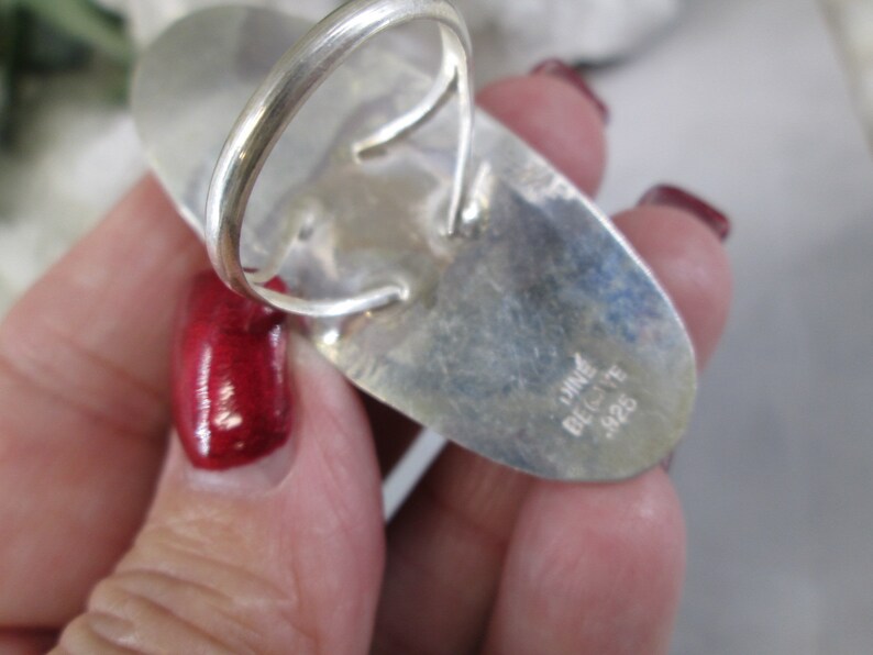 May include: A silver ring with an oval shaped stone. The ring is marked "DINE BELYTE 925".