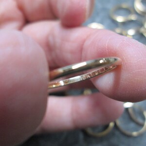 May include: A close-up of a gold-colored metal key ring with the inscription "MADE IN USA" on the inside of the ring.