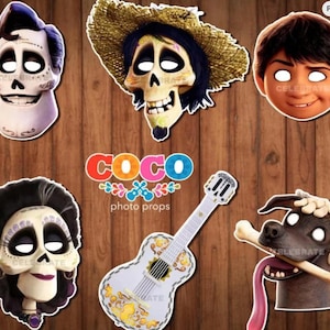 May include: A collection of Coco-themed photo props featuring character cutouts and a guitar. The props include skull-faced characters, a boy's face, and a dog with a bone. The guitar is white with yellow floral designs. The text "COCO photo props" is also visible.