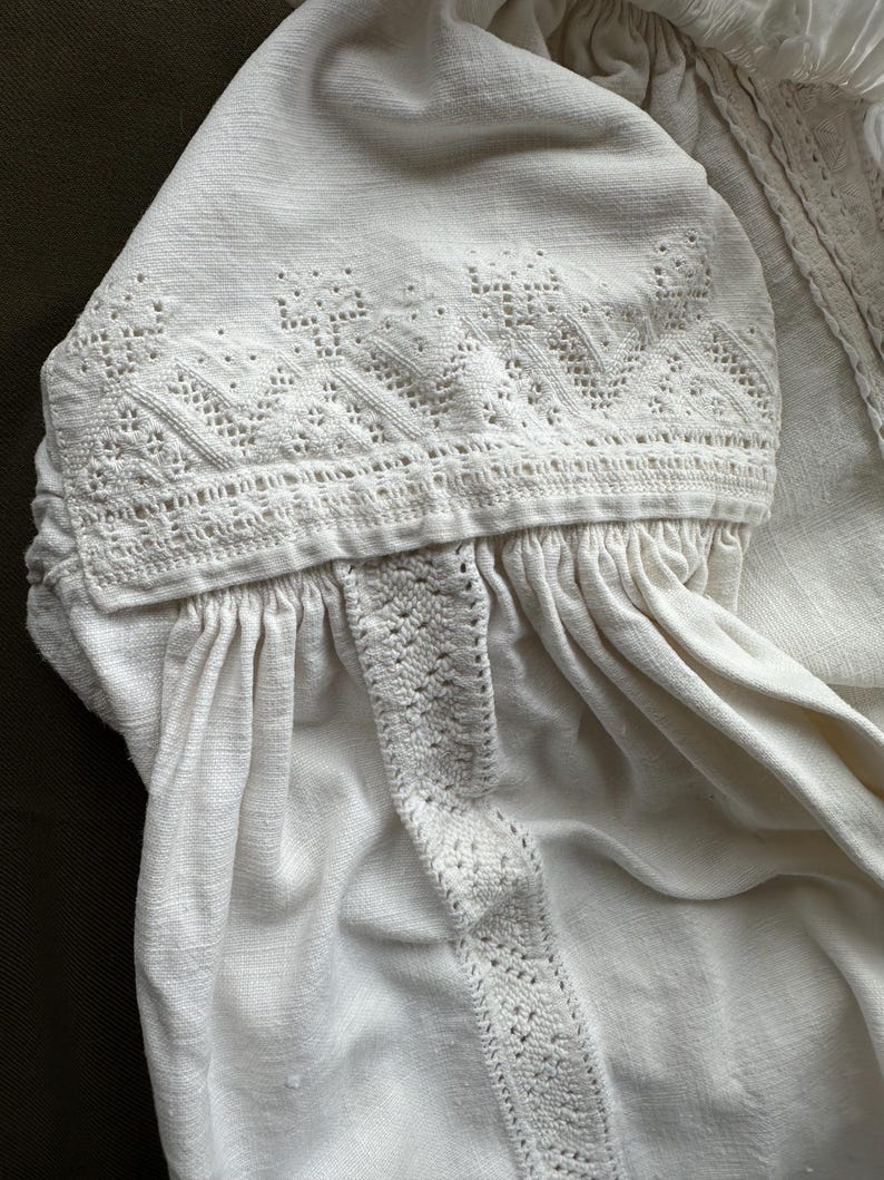 Op de afbeelding: Wit linnen blouse met delicate witte borduurwerk rond de halslijn en mouwen.