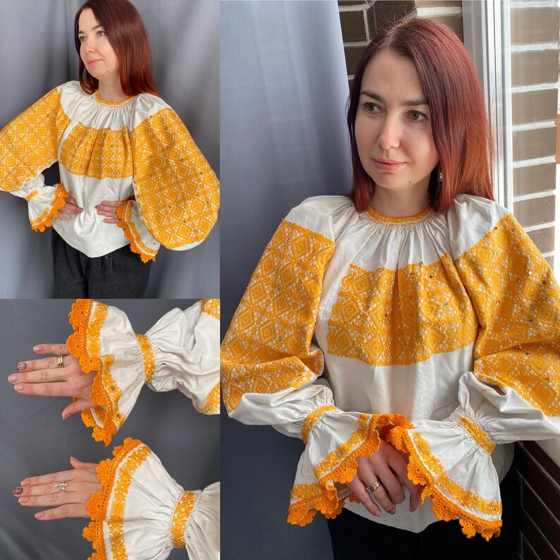 May include: A white embroidered blouse with yellow floral patterns. The blouse has long sleeves with ruffled cuffs and a gathered neckline.