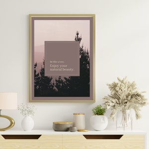 May include: A framed print with a quote about nature. The print features a silhouette of trees against a pink and purple sky. The quote reads "Be like a tree. Enjoy your natural beauty."