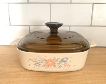 Symphony  Corning Ware Casserole Dish Blue Pink Green Floral Motif With Blue Ribbon On  Cream Background Brown Glass Lid 1990-94   1 Liters