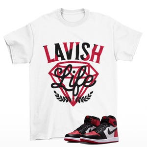 Maglietta da ginnastica Lavish bianca abbinata alle Jordan 1 High OG Ruby