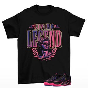 Puede incluir: Camiseta negra con el texto "LIVING LEGEND" sobre un gráfico de una estatua con gafas de sol. Debajo, zapatillas deportivas negras y rosas.