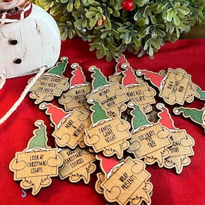 May include: A set of 15 wooden gnome ornaments with different Christmas-themed messages. Each gnome is holding a sign with a different activity, such as "Make a Wish List", "Bake Christmas Cookies", and "Decorate the Tree".
