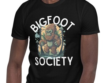 Könnte beinhalten: Ein schwarzes T-Shirt mit einem weißen Aufdruck eines Bigfoots, der einen Ast hält. Der Text "BIGFOOT SOCIETY" ist in Weiß unter dem Aufdruck gedruckt.