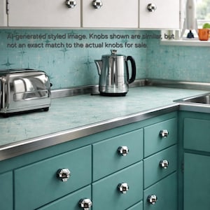 Peut inclure: Une cuisine de style rétro avec des armoires turquoise et des armoires supérieures blanches. Les armoires sont équipées de boutons chromés. Un grille-pain et une bouilloire chromés sont posés sur le comptoir. Le texte de l'image est : "Al-generated styled image. Knobs shown are similar, but not an exact match to the actual knobs for sale."