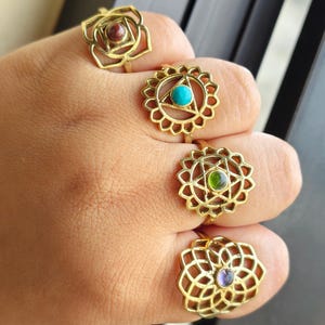 May include: Four gold rings with different colored gemstones in the center. Each ring features a detailed mandala design.