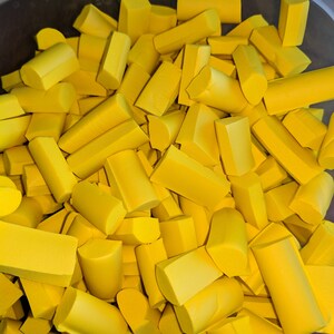 K&ouml;nnte beinhalten: Ein Beh&auml;lter gef&uuml;llt mit gelben Schaumstoffst&uuml;cken in verschiedenen Formen und Gr&ouml;&szlig;en. Die Schaumstoffst&uuml;cke sind alle in der gleichen Farbe und scheinen aus einem gr&ouml;&szlig;eren Schaumstoffst&uuml;ck geschnitten zu sein.