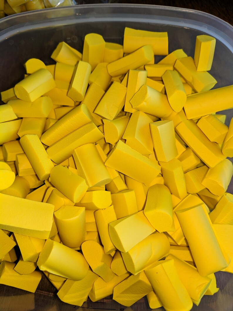K&ouml;nnte beinhalten: Ein Beh&auml;lter gef&uuml;llt mit gelben Schaumstoffst&uuml;cken in verschiedenen Formen und Gr&ouml;&szlig;en. Die Schaumstoffst&uuml;cke sind alle in der gleichen Farbe und scheinen aus einem gr&ouml;&szlig;eren Schaumstoffst&uuml;ck geschnitten zu sein.