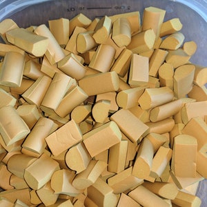 K&ouml;nnte beinhalten: Ein durchsichtiger Plastikbeh&auml;lter gef&uuml;llt mit einer gro&szlig;en Menge kleiner, unregelm&auml;&szlig;ig geformter, brauner Schaumstoffst&uuml;cke. Der Beh&auml;lter ist mit 1/2 Tasse und 1/8 Unze gekennzeichnet.