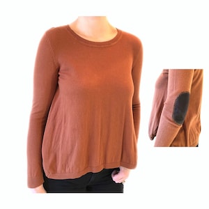 May include: A brown long-sleeved sweater with a round neckline and a patch on the elbow.