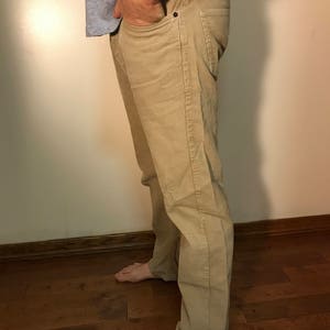 K&ouml;nnte beinhalten: Eine beige Cordhose mit gerader Beinweite. Die Hose hat eine dezente Textur und einen klassischen Stil.