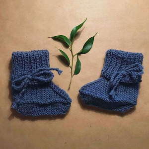 Cute knitted baby boots with ribbed fold and tied bow