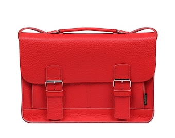 May include: A red leather satchel with two buckles on each side and a shoulder strap. The bag has a small logo on the bottom right corner.