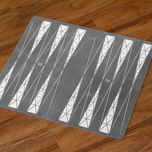 May include: A gray and white checkerboard game board with a geometric pattern. The board is made of a textured material and has a slightly worn look.