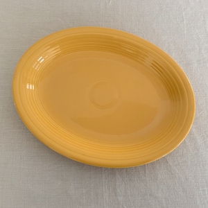 May include: A yellow oval serving platter with a rippled design.