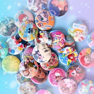 May include: A selection of vibrant, circular badges featuring diverse images and text. Designs include anime characters, cartoon animals, and phrases such as "Bye Bye" and "Miss You." The badges are arranged on a light blue background.
