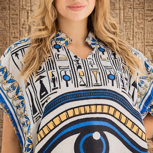 Close-up detail of Egyptian-inspired embroidered border and blue fringe on kaftan fabric