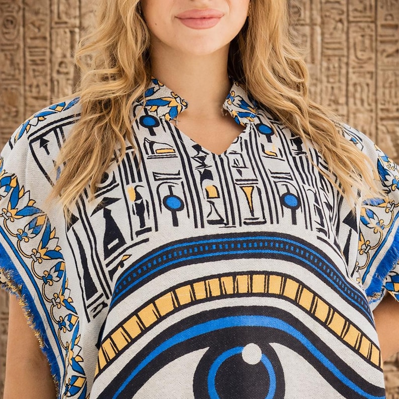 Close-up detail of Egyptian-inspired embroidered border and blue fringe on kaftan fabric