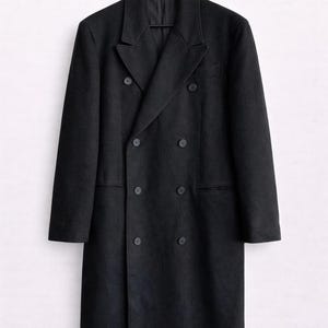 May include: A black double-breasted overcoat with six buttons and a notched lapel, hanging on a black hanger. The coat has two front pockets and a classic, tailored design. The coat is made of a dark, solid-colored fabric.