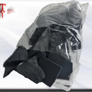 May include: A clear plastic bag filled with black charcoal pieces. The charcoal is in various shapes and sizes.