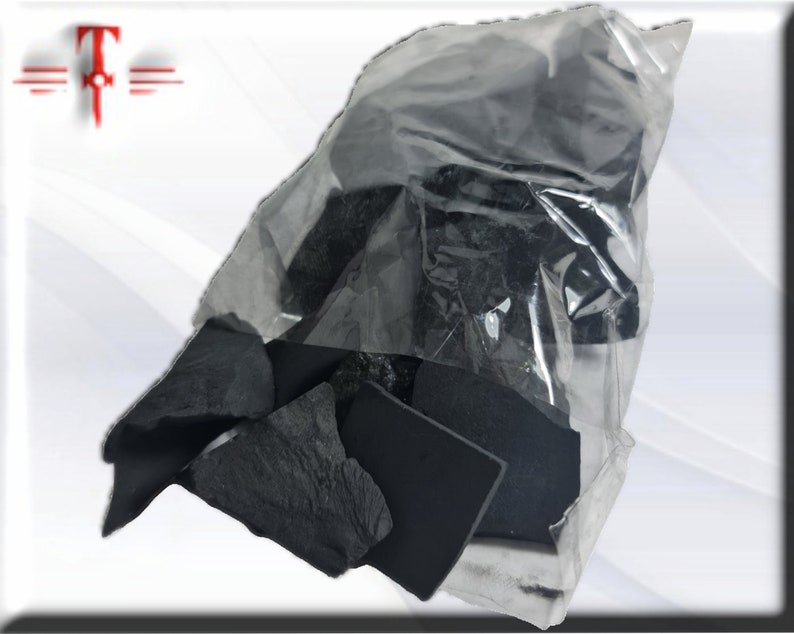 May include: A clear plastic bag filled with black charcoal pieces. The charcoal is in various shapes and sizes.