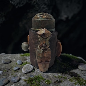 Peut inclure: Une bouteille marron et dorée avec une figurine en bois sculpté. La bouteille a un bouchon texturé. La figurine est finement sculptée avec des formes géométriques. Fond sombre et naturel.