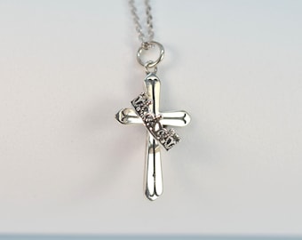 Puede incluir: Collar con cruz de plata y un pequeño dije de corona que dice "Princess".