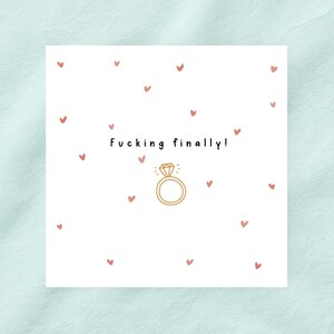 May include: A white card with the text "Fucking finally!" in black, above a gold ring illustration with a diamond. Small pink hearts are scattered across the white background.