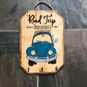 May include: Wooden key holder with a blue Volkswagen Beetle design and the text "Road Trip or Bust!"
