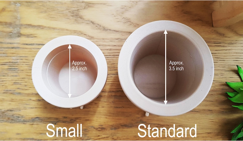 May include: Two white ceramic pots, one labeled "Small" and the other "Standard". The small pot measures approximately 2.5 inches in diameter, while the standard pot measures approximately 3.5 inches in diameter.