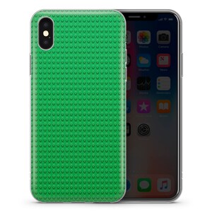 May include: A clear phone case with a green Lego-like pattern. The case is designed to fit an iPhone.