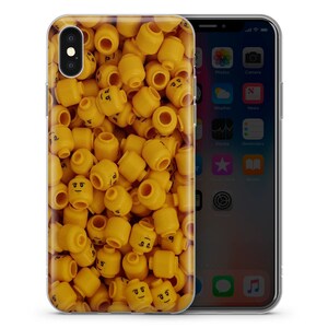 May include: A clear phone case with a design of yellow Lego heads. The case is designed for an iPhone.
