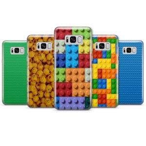 May include: Five different phone cases with a Lego theme. The cases are all for the Samsung Galaxy S8. The cases feature different Lego designs, including a green case with green Lego bricks, a yellow case with yellow Lego heads, a blue case with blue Lego bricks, a red case with red, blue, yellow, and green Lego bricks, and a yellow case with yellow, red, blue, and orange Lego bricks.