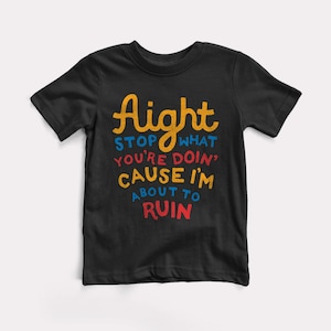 May include: Black t-shirt with the text "Aight Stop What You're Doin' Cause I'm About To Ruin" in colorful lettering.