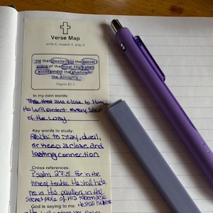Op de afbeelding: Een Verse Map-studieblad met handgeschreven notities over Psalm 91:1, voorzien van een kruisicoon en secties voor persoonlijke reflectie, trefwoorden en kruisverwijzingen. Een paarse intrekbare balpen en de bijbehorende dop liggen op de gelinieerde pagina.