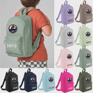 May include: A collection of solid-coloured backpacks featuring a circular Spider-Man graphic on the front pocket. Each bag displays a personalised name in white lettering. The backpacks are available in various colours including sage, lavender, tan, pink, navy, and black.