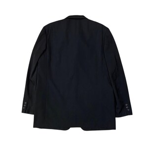 May include: A black blazer with a two-button closure and three buttons on each sleeve. The back of the blazer is visible, showing a classic tailored design. The blazer is made of a smooth, solid fabric.