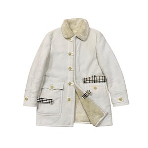 May include: Off-white shearling coat with a cream-colored shearling collar. The coat features gold-colored buttons, two front pockets, and plaid accents. The interior lining is a light cream color.