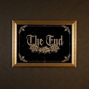 May include: A gold-framed picture with a black background and the words "The End" in gold script. The words are surrounded by a decorative floral design.