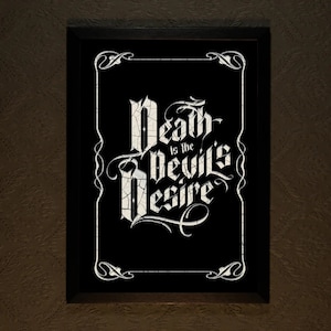 Pode incluir: Arte de parede enquadrado em preto com letras brancas que dizem "Death is the Devil's Desire".