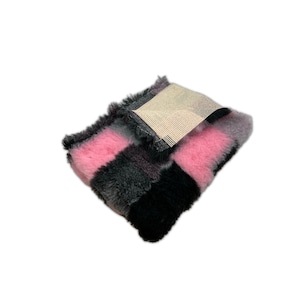 May include: A pink and black striped faux fur fabric swatch. The fabric is soft and fluffy, and it has a subtle sheen.