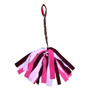 Könnte beinhalten: Ein rosa, weißes und burgunderfarbenes Hundespielzeug mit einem schwarzen und roten Seilgriff. Das Spielzeug besteht aus Stoffstreifen und ist für interaktives Spielen konzipiert.