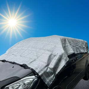 May include: A silver car cover made of a mesh material to protect a car from the sun. The cover is draped over a black car with the front of the car visible.